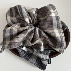 Detailed view of handmade vintage plaid wool scrunchie on a rustic wooden tray