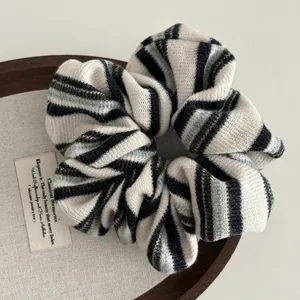 Knitted striped scrunchie in black green and blue yarn for a vintage ponytail style
