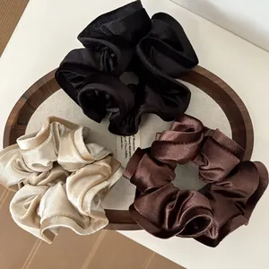 Set de tres coleteros de terciopelo brillante en negro, dorado y marrón para el cabello