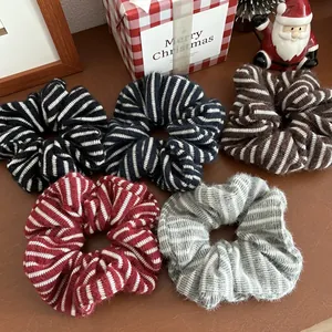 Set aus fünf gestreiften, flauschigen Strick-Scrunchies in verschiedenen Farben auf Holz