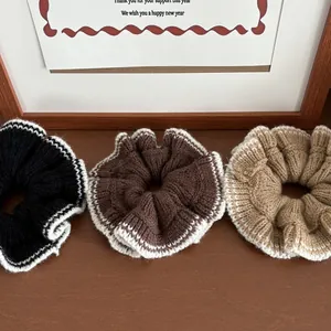 Détail de trois chouchous en maille avec bordure contrastée sur fond en bois