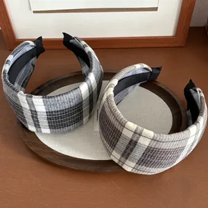 Close-up of thick plaid sponge headbands featuring classic black and brown woven texture