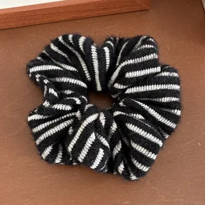 Detailaufnahme von schwarz-weiß gestreiftem Strick-Haargummi mit weicher Mohair-Textur