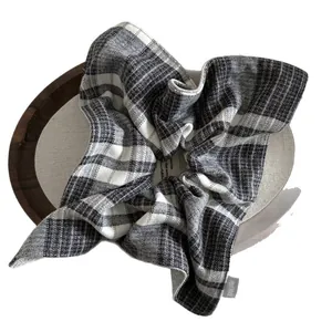 Plaid tweed scrunchie in black and white checkers with a handmade label on wood
