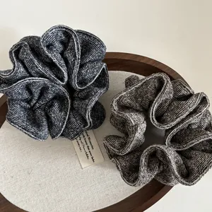 Close-up of knit fabric scrunchies in grey and coffee brown on a wooden tray