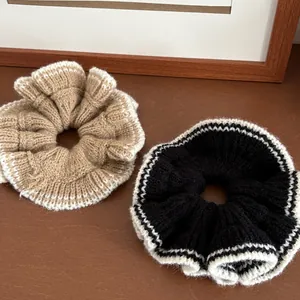 Détail de chouchous en tricot avec bordure en dentelle blanche en kaki et noir