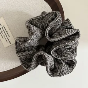 Detailed view of the soft knitted texture and grey marl knit pattern on the scrunchie