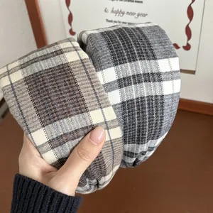 Detail of plaid headband featuring brushed fabric texture in brown and grey check patterns