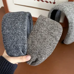 Detailed view of wide knit sponge headbands in dark grey, brown, and light grey textures