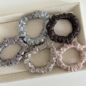 Five elegant satin scrunchies with crystal beads in assorted soft neutral colors