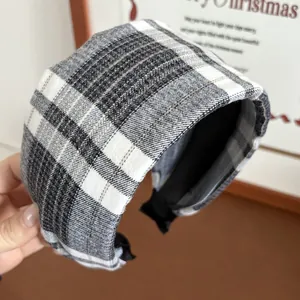 Detail of wide plaid headband in black and white checkers with soft fabric texture