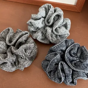 Three-piece set of knitted marl scrunchies in light, taupe, and dark grey textures