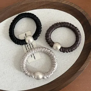 Three-piece set of elegant pleated satin hair ties with pearls in black, brown, and champagne