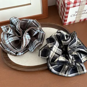 Large plaid scrunchies in blue and brown checkered fabric for elegant bun hairstyles