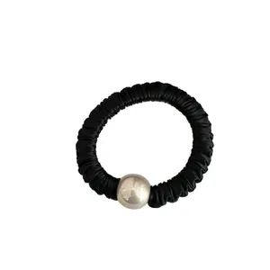 Black pleated satin scrunchie with a silver metallic bead for minimalist ponytail styles