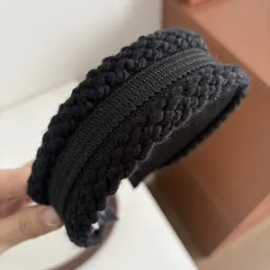 Nahaufnahme des schwarzen Strickstirnbands mit Zopfmuster und geripptem Band-Detail