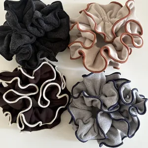 Set of four wool fabric scrunchies with contrast wavy edge stitching in elegant colors