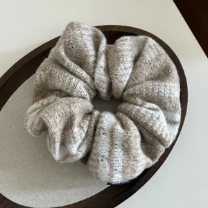 Vista ravvicinata dell'elastico in maglia beige con motivo Fair Isle e etichetta fatta a mano