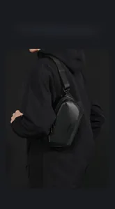 Close-up of waterproof matte black crossbody bag featuring adjustable nylon strap and logo