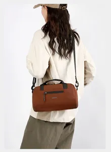 Sac bandoulière cylindrique marron avec poignée et logo imprimé pour le quotidien