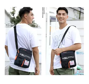 Outdoor street shots of men's waterproof crossbody bag in black and orange contrast
