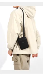 Close-up of minimalist black crossbody sports bag with nylon strap on model