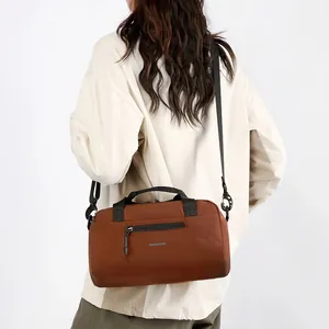 Sac bandoulière cylindrique marron en toile avec sangle noire et logo wepower au style minimaliste