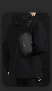 Close-up of waterproof black tactical sling bag featuring magnetic buckle and logo detail