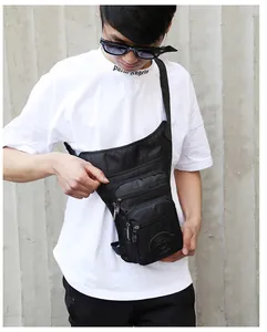 Detailed view of black tactical drop leg bag with multiple zipper pockets on a male model