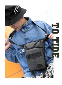 Detail of dark grey tactical leg bag showing multi-zipper pockets and durable fabric texture
