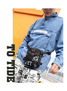 Détail de la sacoche en nylon noir avec imprimé journal et cordon de serrage orange
