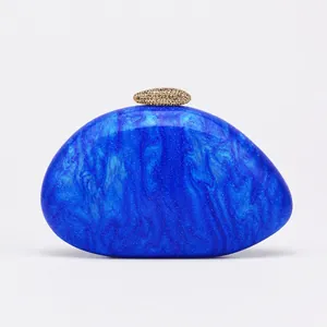 Detailed view of the blue marble texture on the shell-shaped acrylic clutch bag.