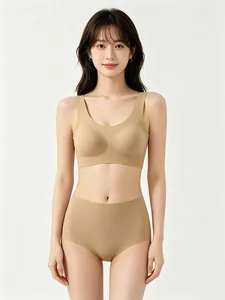 Vista frontale di un set reggiseno e slip senza cuciture color carne su modella