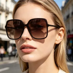 Close-up of stylish oversized sunglasses with dark gradient lenses on female model