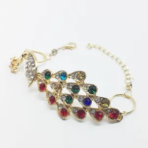 Close-up of golden peacock bracelet featuring colorful rhinestones and adjustable lobster clasp