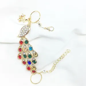 Detailed view of peacock slave bracelet with colorful rhinestones and adjustable gold chain