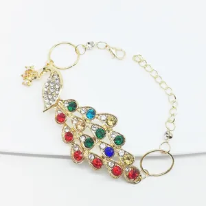 Macro view of golden peacock bracelet showing colorful rhinestones and lobster clasp