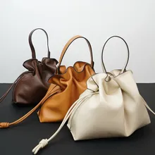 Set of three minimalist genuine leather drawstring tote bags in brown, tan, and cream colors