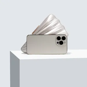 Shell shaped acrylic clutch bag with pearl luster and size reference to a smartphone
