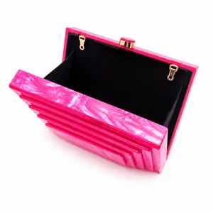 Open view of pink marble acrylic evening clutch bag with black lining and gold hooks.