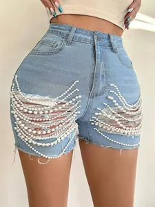 Détail de short en jean taille haute bleu clair avec chaînes de perles décoratives