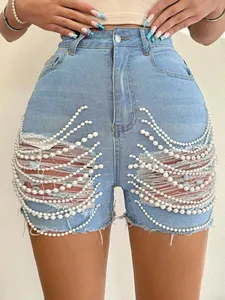 Détail du short en jean bleu clair à taille haute avec déchirures et franges de perles