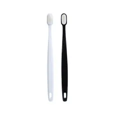 Detail of minimalist black and white toothbrushes with ultra-fine bristles and hanging holes