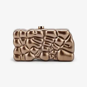 Detailansicht einer metallischen bronzefarbenen Acryl-Abendclutch mit Goldverschluss