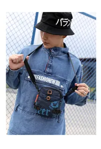 Détail du sac bandoulière bleu marine avec patch en caoutchouc et cordon de serrage orange