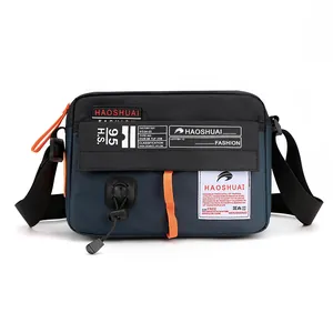 Sac bandoulière en nylon imperméable bleu et noir avec accents orange pour sport et voyage