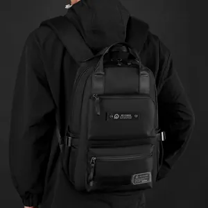 Black multi-compartment commuting backpack with waterproof matte finish on a model