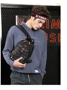 Detail of waterproof black nylon chest bag with orange zipper accents and street style