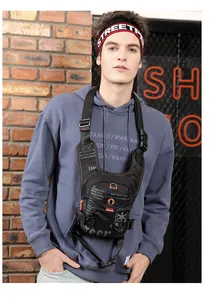Detail of tactical chest bag with orange stitching and white text on a brick background
