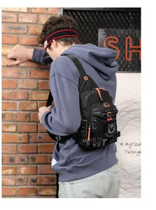 Nahaufnahme der schwarzen Brusttasche mit orangefarbenen Zippern und Street-Graffiti